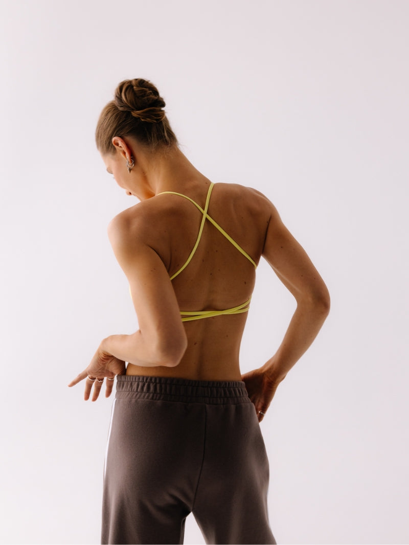 Żółty damski stanik sportowy Breeze - outfit z szerokimi spodniami w brązie