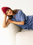Modelka w niebieskim zestawie Coast relaksuje się siedząc - bluza i szorty w kolorze Timeless Blue